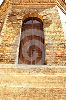 Old wooden door in yellow brick water tower wall downstairs view