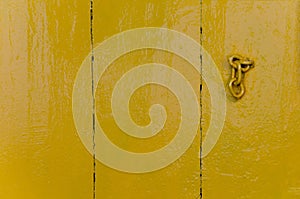 old wooden door in yellow. painted wood texture. part of the door chain. background for your company