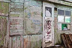 Old wooden doors on a collapsing building, a vintage barn, peeling paint, littered planks
