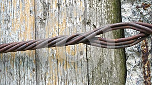 Old wooden electric pole. A wooden pole tied with iron wire. Texture of old wood, concrete and rusty wire.