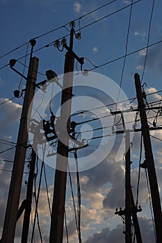 Old wooden electric poles on a background of blue cloudy sky