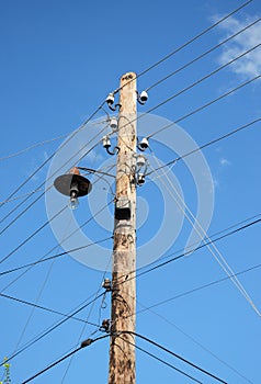 Old wooden electric post power pole. Power line. Wooden Utility Pole with light Bulb.
