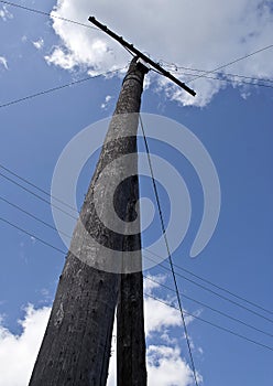 Old wooden electricity pole, wires, blue sky