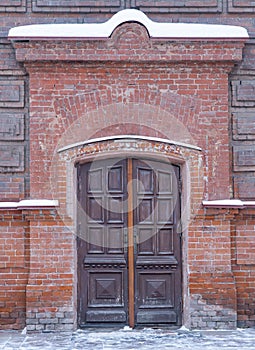 old wooden entrance doors. massive door in a brick building.