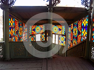 Old wooden entrance hall and stairs with colorful stained glass windows.