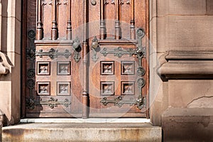 Old wooden exterior doors with decorative panels, brass doorknobs photo