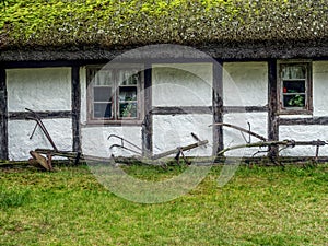 Old wooden farmstead with historical farming implements