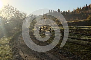 Old wooden fence along the dirt rural road in the early autumn morning