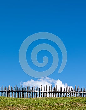 Old wooden fence on a blue sky background