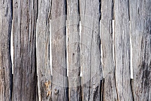 Old wooden fence made of rough and uncouth planks, darkened with time, in daylight, isolated on white background