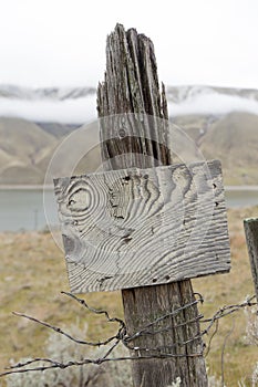 Old wooden fence post and rustic sign