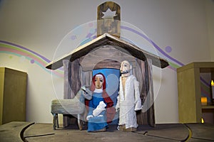 Old wooden figures of a man with a beard, a woman with a baby, a sheep in a wooden house. Christmas, Christianity,