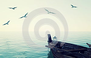 Old wooden fishing boat floating over calm blue sea and sky