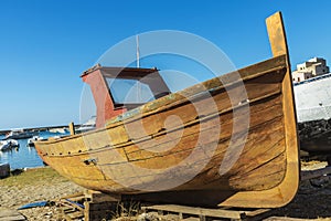 Old wooden fishing boat moored on the beach in Italy