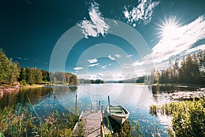 Old Wooden Fishing Boat Moored Near Pier In Summer Lake Or River. Beautiful Summer Sunny Day Or Evening. Swedish Nature