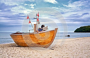 Old wooden fishing boat on sandy beach in the Baltic Sea resort of Binz. Island RÃÂ¼gen, Germany photo