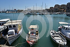 Old wooden fishing boats moored in port in Heraklion near the city center.