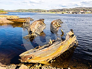 Old wooden fishing boats sinked in the sea. Teriberka, Murmansk Oblast, Russia