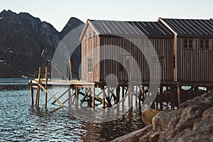 Old wooden fishing houses near the lake against the background of the mountains. Norway, Europe. Copy space. Can use as banner