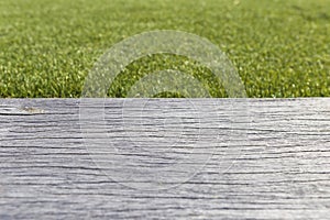 Old wooden floor with blurred green grass background