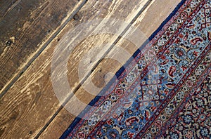 Old wooden floor with old handmade wooven rug in a farm house
