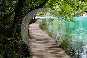 Old wooden footpath with blue water grass and trees in National Park Plitvice Lakes in Croatia