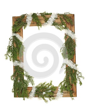 Old wooden frame entwined with a festive garland with fir branches isolated on a white background