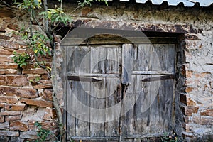 Old wooden gate doors and stone wall