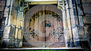 Old wooden gate of a stone church