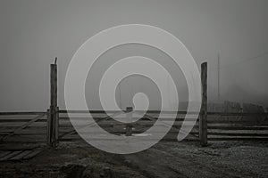 Old wooden gates and fog behind them.