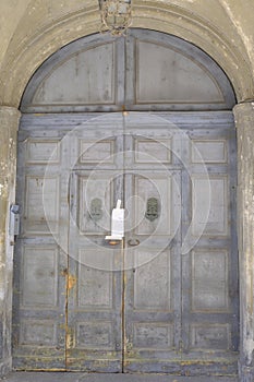 old wooden gray door of the building. Building exterior, facade