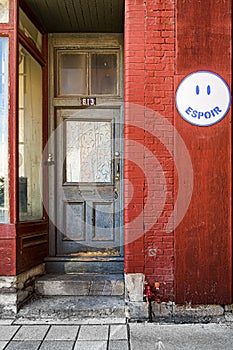 Old wooden gray door with a hope sign at the 813 Saint Paul street Old Montreal