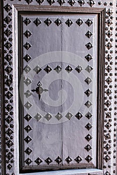 Old wooden gray door with wrought iron details