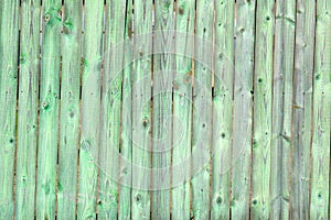 Old wooden green background of boards with cracked and paint. Fence. Wooden texture.