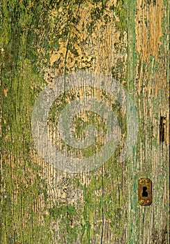 An old wooden green door with a rusty lock.