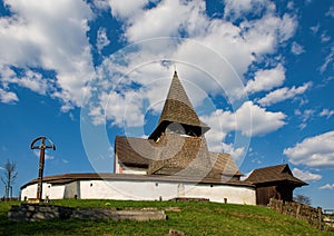Old wooden historic fortified church, sunny day during early spring, blue sky with clouds.