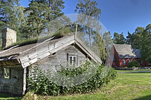 An old wooden house with a Church from the 1690s in the background in HDR