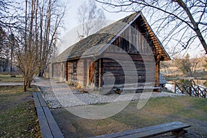 Old wooden house on the edge of forest near the lake in spring season. Fishing village. Traditional exterior in soviet or russian