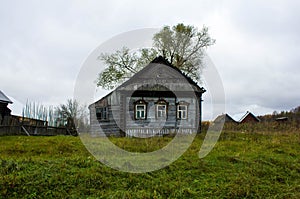 Old wooden house gray in a village in the Ivanovo region in Russia. The house, standing alone on a dull cloudy day in the