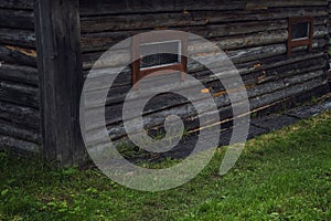 An old wooden house with metal bars on small windows. Close-up. Home prison