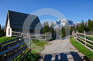 Old wooden house in the Montenegro. Road, fence, mountains and forest near.