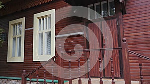 Old wooden house in summer. Stock footage. Staircase with entrance to old wooden house. Beautiful facade of old house