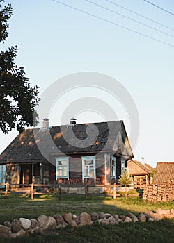 Old wooden house in village. Farmhouse in Belarus. View of rustic ethnic house on sunset. rural landscape