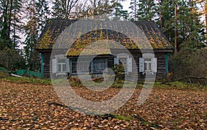 An old wooden house with white window shutters in the fall