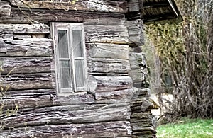 old wooden house with wooden window pane and dog house in the background