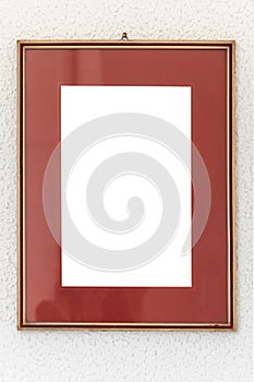 Old wooden Image frame decorated with gold on a white textured wall.