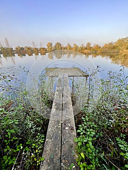 Old wooden jetty at a lake in autumn