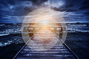 Old wooden jetty during storm on the ocean. Abstract light