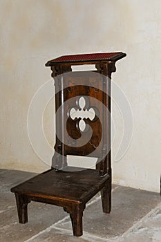 Old wooden kneeler  or prayer stool in a catholic church