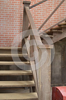 Old wooden ladder in the house with a handrail.